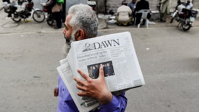 A man in Lahore carries newspapers detailing the meeting between the US and Iran in Islamabad. Reuters