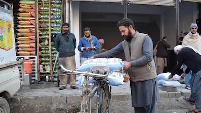 Yousaf Jan loads two bags of flour on to his bicycle, after waiting three days for the food staple. All pictures: Haroon Janjua for The National.