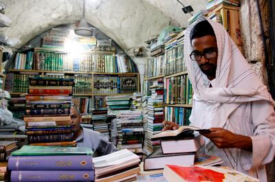 A religious student pages a book at the Howeish book market. AFP