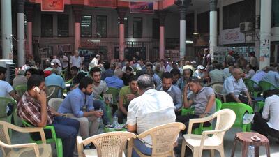 Men drink chat with friends over cups of teas in a shaded courtyard off Mutanabbi Street in Baghdad on June 17, 2016. Florian Neuhof for The National
