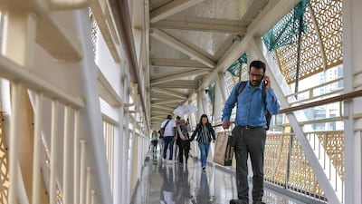 Pedestrians get some shelter from the elements in the overpass at Abu Dhabi Central Bus Station. Victor Besa / The National