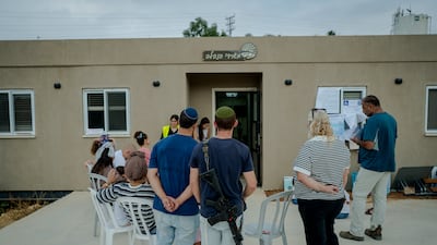 Israeli voters, including an armed civilian, wait in line outside a polling station to cast their ballots in the occupied West Bank. Getty images