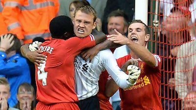 Simon Mignolet, centre, is mobbed by Liverpool teammates after his penalty save on Satuday. Andrew Yates / AFP