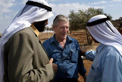 In a photo from October 2002, Israeli writer Amos Oz talks with Palestinian men after picking olives in the West Bank village of Aqraba, south of Nablus. AFP