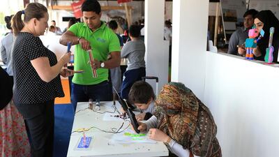 Visitors creating art with 3 doodlers and a 3D printing device. Ravindranath K / The National