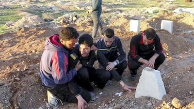 IDLIB, SYRIA - APRIL 6: Abdel Hameed Alyousef (2nd L) mourns over his wife and twin babies, killed in the chemical attack by Assad Regime, at their cemetery in Idlib, Syria on April 6, 2017. Abdel Hameed Alyousef lost his wife and 9 month old twin babies named Aya and Ahmad in addition to 13 of his family members in the chemical attack. The grief-stricken father said: " Dear God took Ahmad and Aya, I am not upset over this. Gulf countries do not deliver an international society which they speak of. We will be patient until the last day and the victory will come. We are not the first nor the last. Our children have been dying in our hands for 6 years. No one seems to help." Assad Regime struck Khan Shaykhun district of Idlib in Syria with a chemical weapon leaving at least 100 civilians, including women and children, dead and at 500 affected from the gas. (Photo by Mohammed Al Daher/Anadolu Agency/Getty Images)