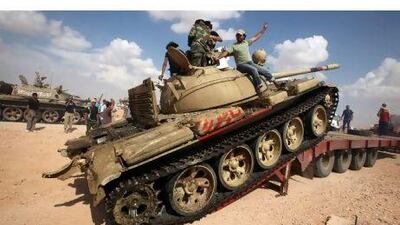 Libyan rebels unload a tank transported to be use to fight against Qaddafi forces, outside Bani Walid , south of Tripoli. MOHAMED MESSARA / EPA