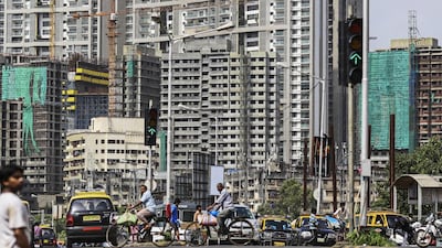 Cyclists and traffic pass in the Chembur area of Mumbai. Indian property has struggled under weak economic conditions, but is expected to rebound this year. Dhiraj Singh / Bloomberg