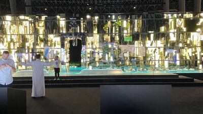 A visitor gets his photograph taken beside a model of The Line.