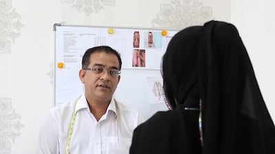 Tailor Azhar Hussain with a client at the Thimble tailoring shop in Bur Dubai. Pawan Singh / The National