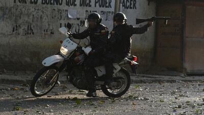 A riot policeman on a motorcycle points his gun during clashes with anti-government demonstrators in the neighborhood of Los Mecedores, in Caracas, on January 21, 2019. AFP