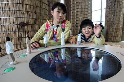 Young Japanese interact with an exhibit on the space exploration ambitions of the UAE. Victor Besa / The National
