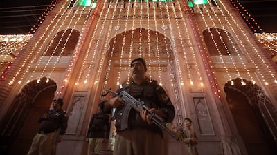 Pakistani security officials stand guard outside a mosque during the 27th night of Ramadan in Peshawar. EPA