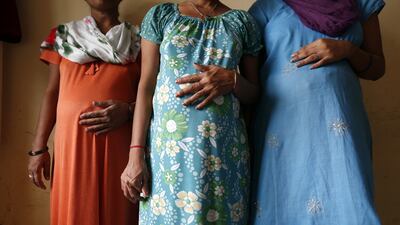 Surrogate mothers (L-R) Daksha, 37, Renuka, 23, and Rajia, 39, pose for a photograph inside a temporary home for surrogates provided by the Akanksha Infertility Clinic in Anand on August 27, 2013. Mansi Thapliyal/Reuters