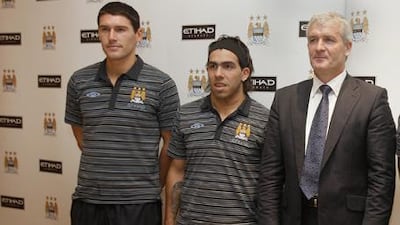 Mark Hughes, the Manchester City, right, at the Emirates Palace with new signings Gareth Barry, left, and Carlos Tevez.
