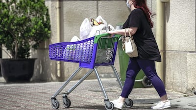 A grocery shopper with a face mask on at Souk Planet, Khalifa City. Face masks should be worn at all times when outside the home, the UAE government said on Saturday. Victor Besa / The National