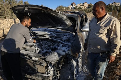 Palestinians inspect a burnt-out car that was torched in an attack allegedly carried out by Israelis from the Bat Ayin settlement in the occupied West Bank. AFP