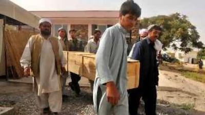 Hospital workers carry the coffin of one of three aid workers killed in an attack in Logar province in August.