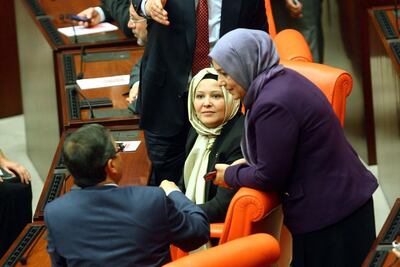Turkey's ruling AKP MPs Nurcan Dalbudak, centre, and Sevde Beyazit Kacar, right, attend a general assembly at the parliament wearing headscarves on Thursday. AFP