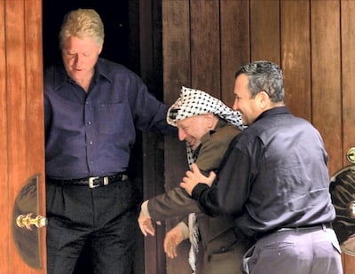 Former Israeli Prime Minister Ehud Barak (R) jokingly pushes former Palestinian President Yasser Arafat (C) into the Laurel cabin on the grounds of Camp David as former US President Bill Clinton watches during peace talks, on July 11, 2000. Arafat and Barak were insisting that the other proceed through the door first. Camp David is the venue where Egypt and Israel made peace in September 1978, and the Laurel cabin was the site of many of the meetings. Reuters