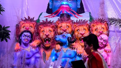 A Bangladeshi hindu devotee walk past the goddess Durga as she arrives for a prayer during at the Durga Puja festival at a temple in Dhaka, Bangladesh. AFP