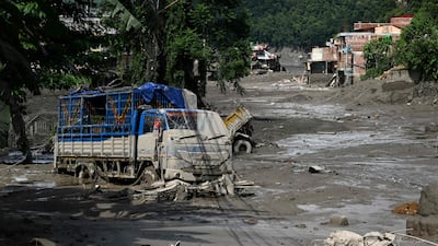 Houses and lorries lie deluged in sludge in Trishuli Bazar. AFP