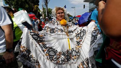 A woman dressed in a Panamanian folk dress dances as she waits for Pope Francis to ride by. AP Photo