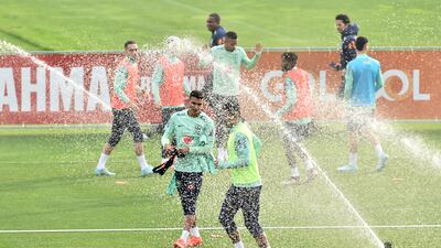 Brazil's Thiago Silva with teammates as the sprinklers go off during training. Reuters