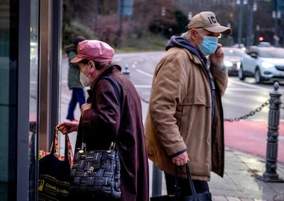 Two elderly people in face masks stand near an elevator during the coronavirus pandemic in Frankfurt, Germany, Thursday, Jan. 14, 2021. (AP Photo/Michael Probst)