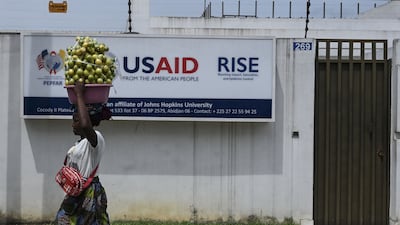 A street vendor walks past the USAID office in Abidjan on March 22. AFP