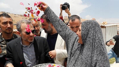 A Syrian refugee welcomes Lebanese Foreign Minister Gebran Bassil during his visit to a refugee camp in Arsal, near the border with Syria. AP Photo