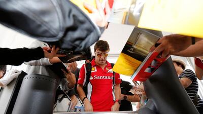 Tickets please: Ferrari F1 driver Fernando Alonso of Spain goes through a turnstile before the third practice session of the Japanese Grand Prix. Kim Kyung-Hoon / Reuters