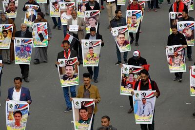 Iraqis hold pictures of killed demonstrators in Baghdad's Tahrir Square, on December 6, 2019. AFP