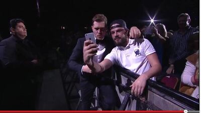 A screenshot from Michael Buble's concert video showing Anonymous Glenn and Michael Buble taking a selfie.