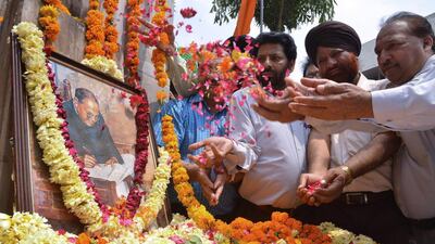 Members of the Shri Guru Ravidass Welfare Society place flowers around a photograph of Indian social reformer, B R Ambedkar to mark his 124th birth anniversay in Amritsar on April 14. AFP Photo
