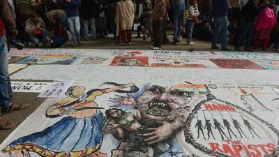 Bystanders look at a banner featuring images of 'government and rapists' in New Delhi after a cremation ceremony for a gang rape victim on December 30, 2012. Several filmmakers are now tackling the subject. Raveendran / AFP