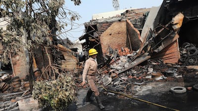 A firefighter walks among burnt debris near Gokulpuri metro station area after clashes in New Delhi, India. EPA