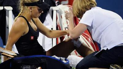 Caroline Wozniacki receives treatment on ner knee during her opening match defeat at the US Open