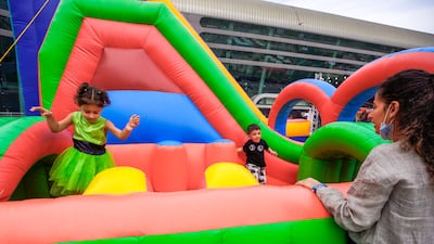Children enjoy an inflatable playhouse in the Party Plaza area.