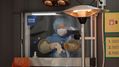 A medical worker prepares to take a sample at coronavirus testing site in Seoul, South Korea. AP Photo