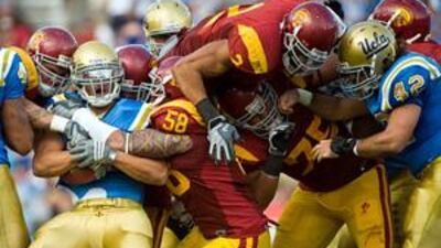 A game between the USC Trojans and the UCLA Bruins illustrates the helmets and shoulder pads that are a feature of American Football.