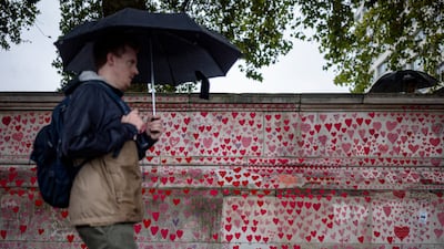 A man walks along the National Covid Memorial Wall in London. A report has said mistakes, delays and failures in the UK's Covid-19 response cost lives. Getty Images