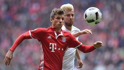 Bayern Munich striker Thomas Mueller and Mainz defender Alexander Hack vie for the ball during their Bundesliga match in Munich, on April 22, 2017.Christof Stache / AFP