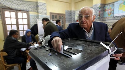 An Egyptian man casts his ballot during the first day of voting on the new constitution at a polling station in the Abassyia neighborhood, Cairo. Khaled Elfiqi / EPA