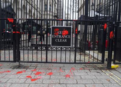 Two people were arrested on suspicion of criminal damage after 'bloody handprints' were left on the gates of Downing Street in London. PA