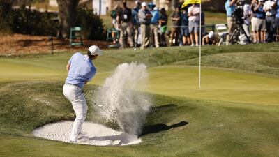 McIlroy hits out of a bunker on the ninth. EPA
