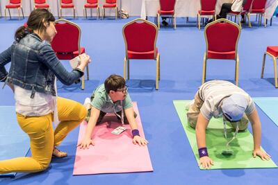 Participants learn yoga techniques in the Special Olympics Healthy Athletes area. Antonie Robertson / The National
