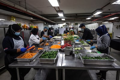 Hotel staff prepare vegetables for cooking in a kitchen of the Grand Seasons Hotel in Kuala Lumpur this month. Many suchy enterprises prepare 1,000 portions daily of food for homeless people and frontliners. EPA