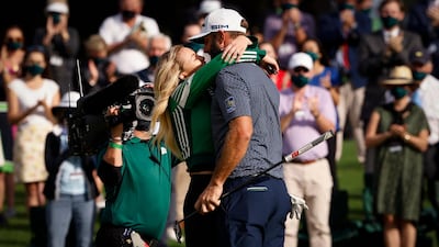 Dustin Johnson celebrates with his partner Paulina Gretzky on the 18th green. Reuters