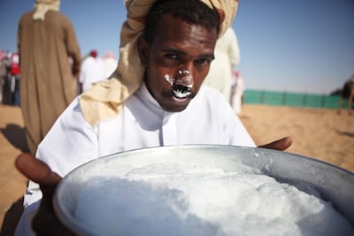 A camel farmer drinks fresh camel milk from a bowl after a milking competition at the Camel Festival in Madinat Zayed in 2010. Galen Clarke / The National